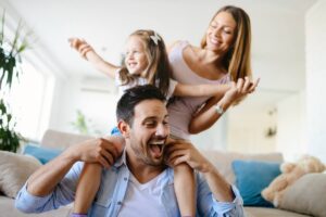 famiglia felice padre madre e figlia sulle spalle
